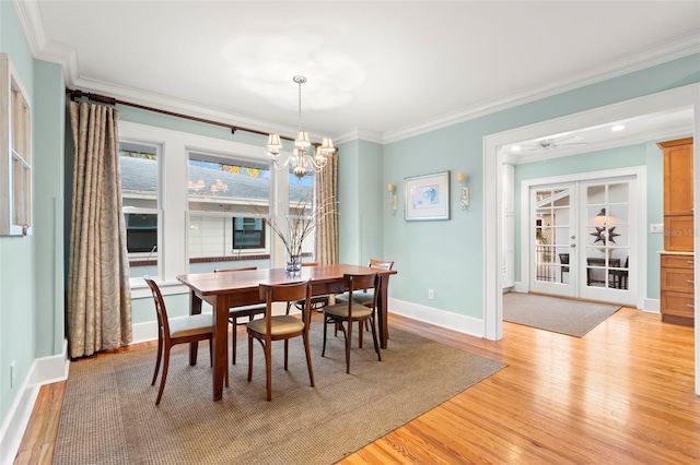 dining room with ornamental molding, light wood-type flooring, and french doors