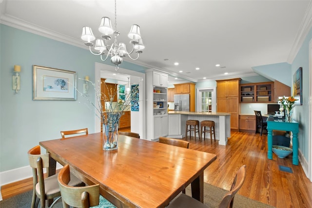 dining space featuring recessed lighting, a notable chandelier, baseboards, light wood-type flooring, and crown molding