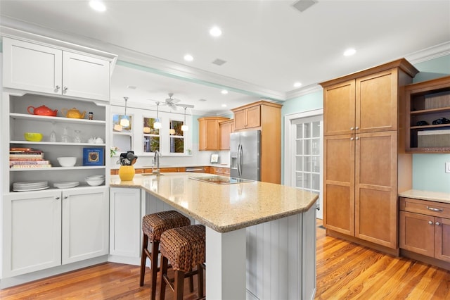 kitchen featuring pendant lighting, white cabinets, stainless steel refrigerator with ice dispenser, and a kitchen breakfast bar