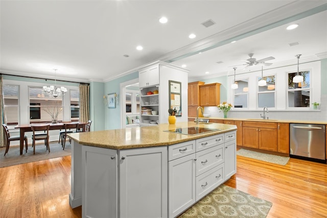 kitchen featuring hanging light fixtures, stainless steel dishwasher, brown cabinetry, and a sink