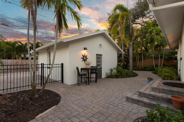 patio terrace at dusk featuring fence