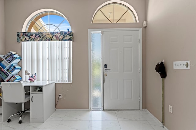 foyer featuring light tile patterned floors and a wealth of natural light