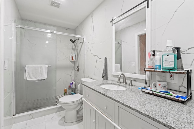 bathroom with tile patterned flooring, a shower with door, toilet, and vanity