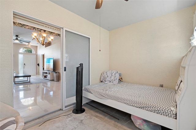 tiled bedroom featuring ceiling fan with notable chandelier