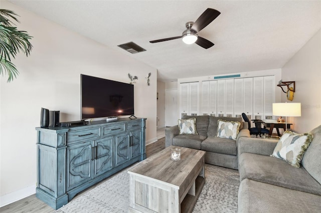 living room featuring ceiling fan and light wood-type flooring