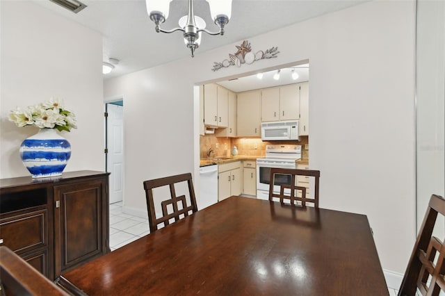 tiled dining room featuring sink and a notable chandelier