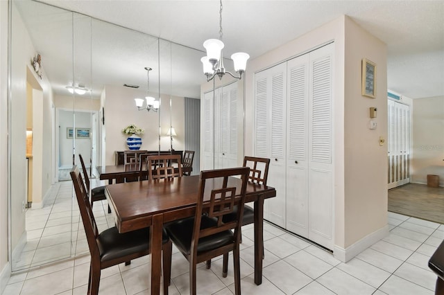 dining space with light tile patterned flooring and a notable chandelier