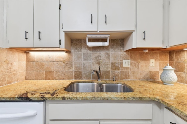 kitchen with tasteful backsplash, sink, white cabinets, and light stone counters