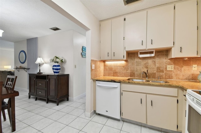 kitchen featuring white appliances, light tile patterned floors, sink, and backsplash