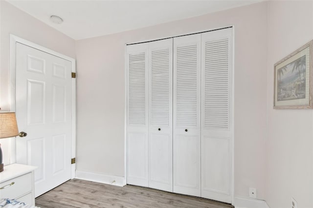 unfurnished bedroom featuring a closet and light wood-type flooring