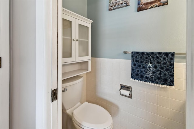 bathroom featuring toilet and tile walls