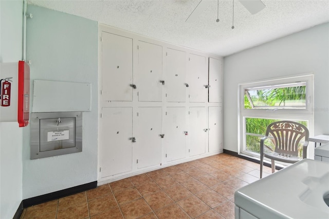 unfurnished office featuring light tile patterned flooring and a textured ceiling