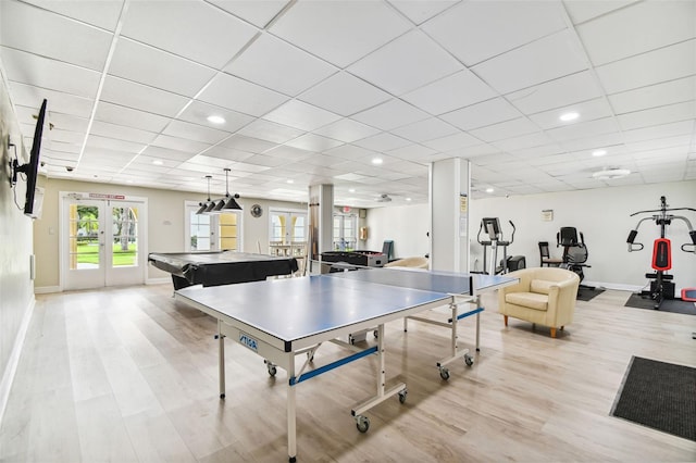 game room with french doors, a paneled ceiling, and light hardwood / wood-style floors