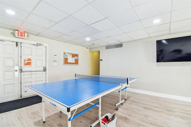 recreation room featuring a paneled ceiling and light wood-type flooring