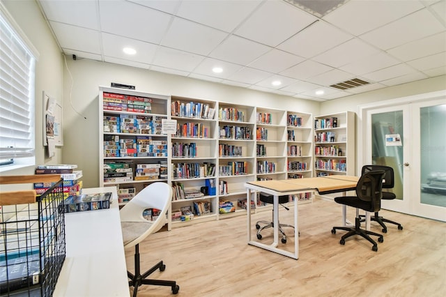 home office with french doors, a paneled ceiling, and wood-type flooring