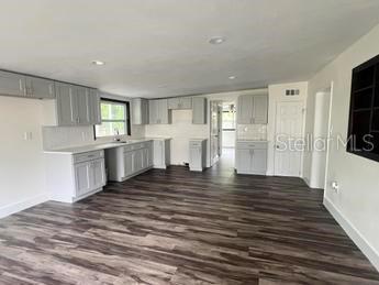 kitchen with decorative backsplash, dark wood-type flooring, and gray cabinets