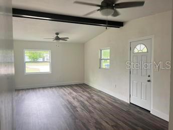 entrance foyer featuring lofted ceiling with beams, wood-type flooring, and ceiling fan