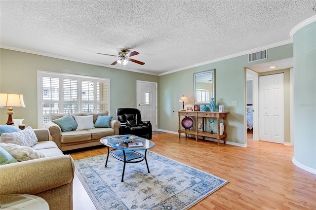 living room featuring light hardwood / wood-style floors, a textured ceiling, crown molding, and ceiling fan