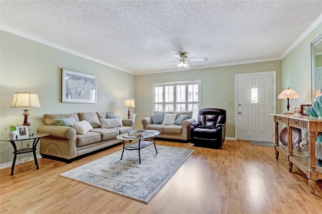 living room with ornamental molding, ceiling fan, a textured ceiling, and light hardwood / wood-style flooring