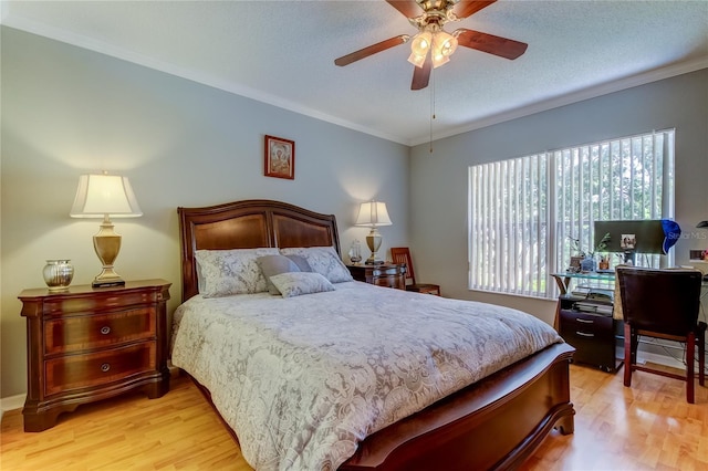 bedroom featuring crown molding, light hardwood / wood-style floors, ceiling fan, and a textured ceiling