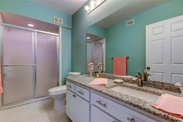 bathroom featuring vanity, toilet, and a shower with shower door