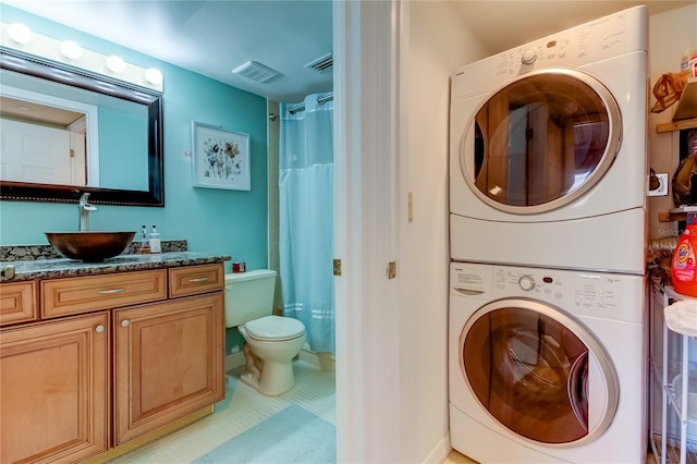 laundry area with sink and stacked washer / dryer