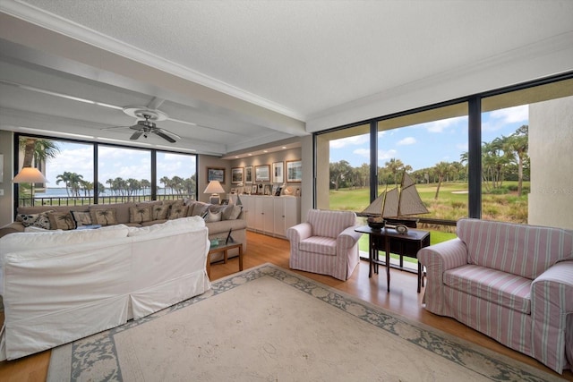 living area with crown molding, a textured ceiling, ceiling fan, and wood finished floors