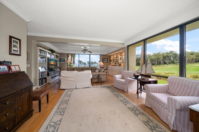 living room with ceiling fan, ornamental molding, a textured ceiling, and light wood-style floors