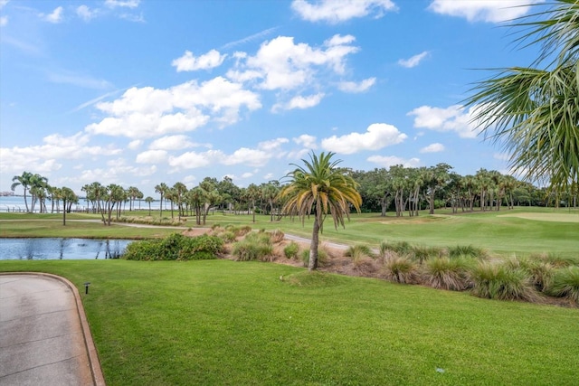 view of home's community with a water view and a lawn