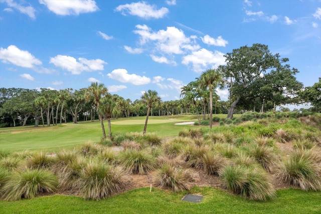 surrounding community with view of golf course and a lawn