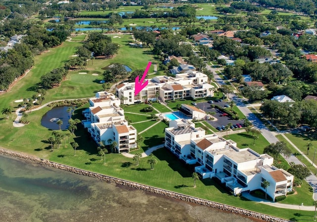 drone / aerial view featuring view of golf course and a water view