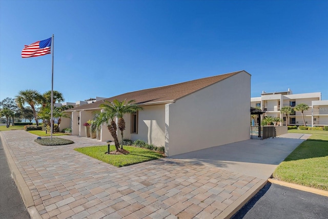 exterior space with a garage, decorative driveway, and stucco siding