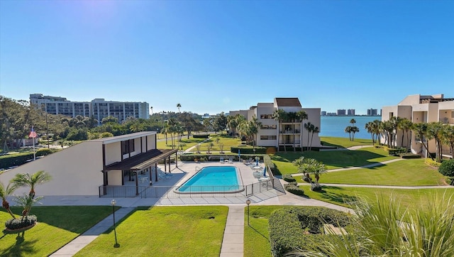 community pool featuring a lawn and a patio