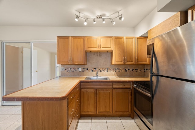 kitchen with sink, electric stove, stainless steel fridge, kitchen peninsula, and light tile patterned floors