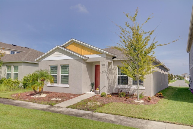 view of front of property with stucco siding, board and batten siding, and a front yard