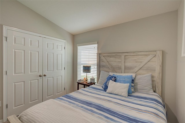 bedroom featuring lofted ceiling and a closet