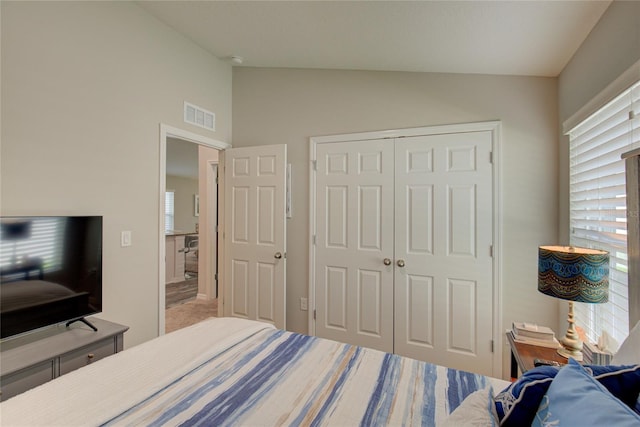 carpeted bedroom featuring lofted ceiling, multiple windows, a closet, and visible vents