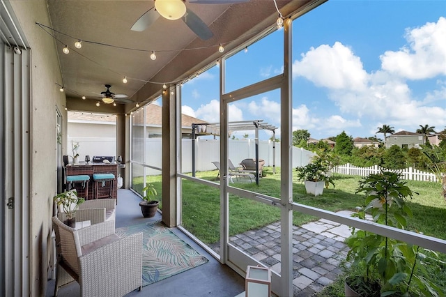 sunroom / solarium featuring ceiling fan