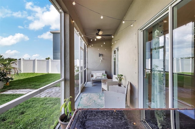 sunroom / solarium featuring ceiling fan