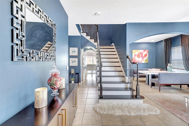 stairs featuring light tile patterned flooring