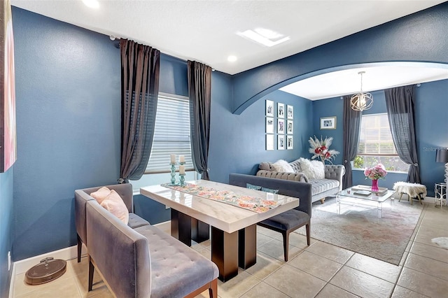 tiled dining room with an inviting chandelier