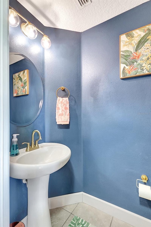 bathroom with a textured ceiling and tile patterned flooring