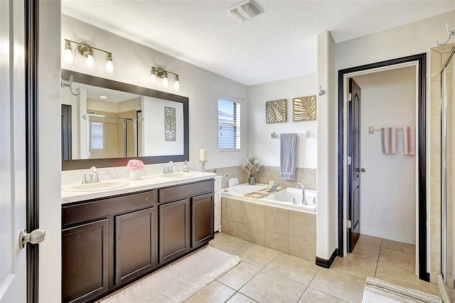 bathroom with tile patterned floors, plus walk in shower, a textured ceiling, and dual bowl vanity