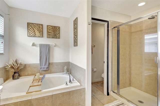 bathroom featuring tile patterned floors, toilet, and separate shower and tub