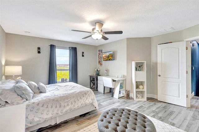 bedroom featuring a textured ceiling, ceiling fan, and light wood-type flooring