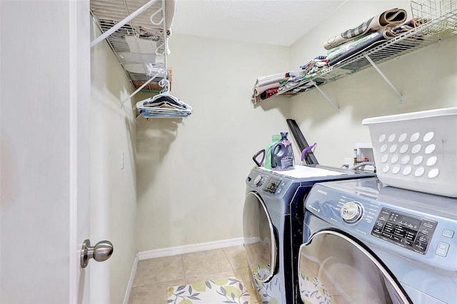 laundry area featuring washer and dryer and light tile patterned floors