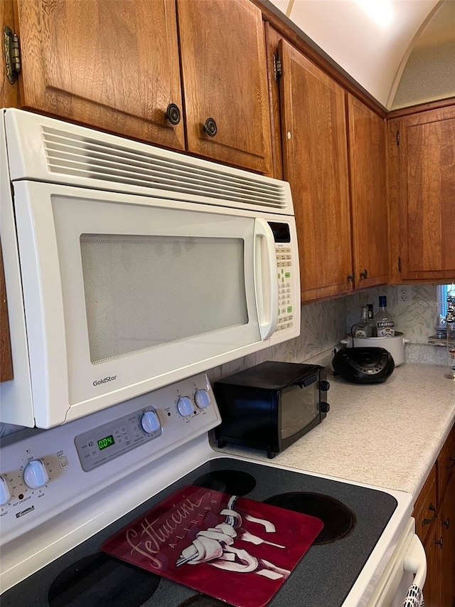 kitchen with decorative backsplash and white appliances