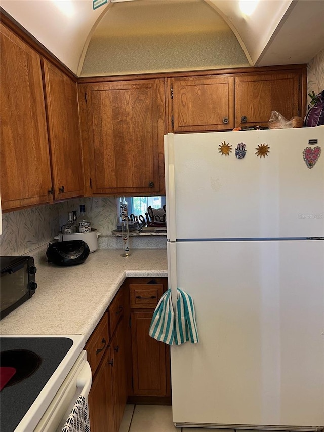 kitchen featuring decorative backsplash and white appliances