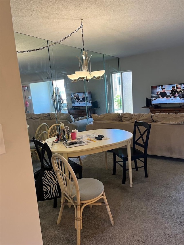 carpeted dining area with a notable chandelier and a textured ceiling