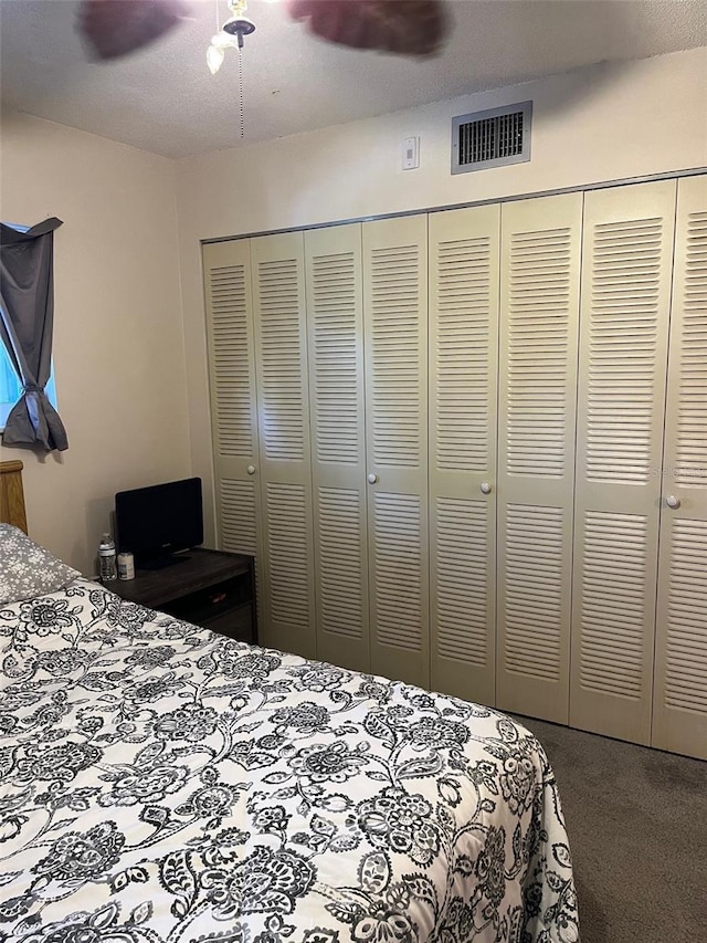 bedroom with carpet floors, ceiling fan, and a closet